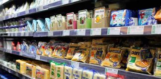 Los peligros del consumo de alimentos procesados Estantería de supermercado con alimentos procesados